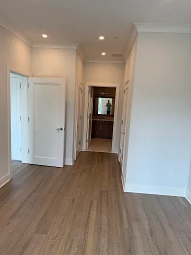 Renovated hallway with wood-look flooring and white doors