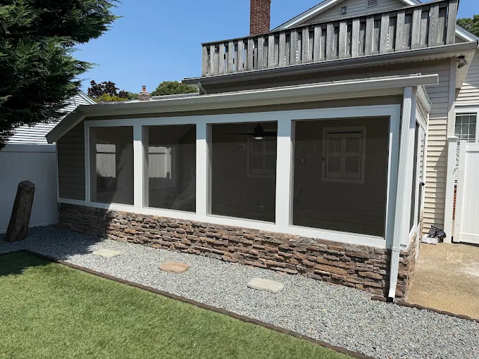 Screened porch with white trim and stone veneer