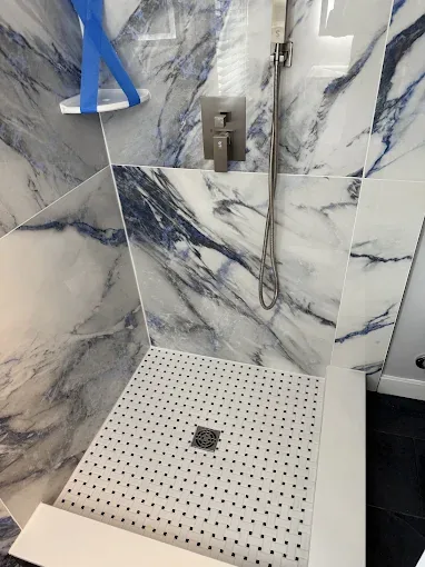 Walk-in shower with blue veined marble wall tile
